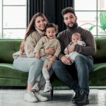 a family sitting on a green couch in a living room
