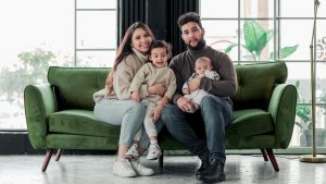 a family sitting on a green couch in a living room
